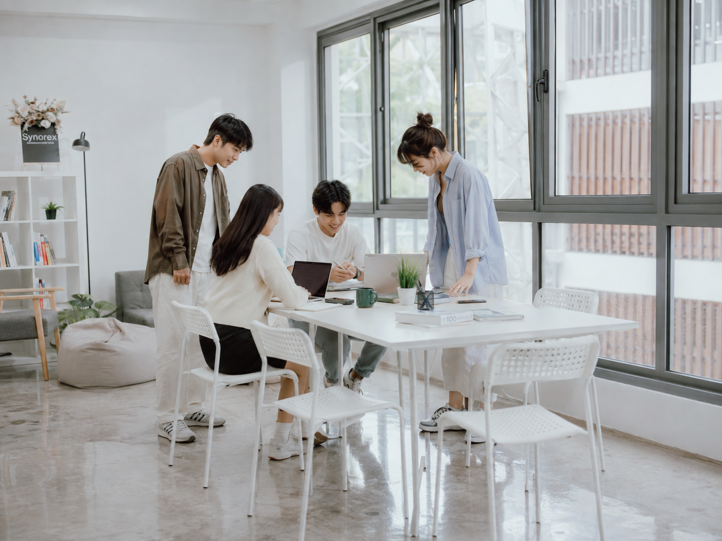 Synorex team collaborating in a bright office meeting area